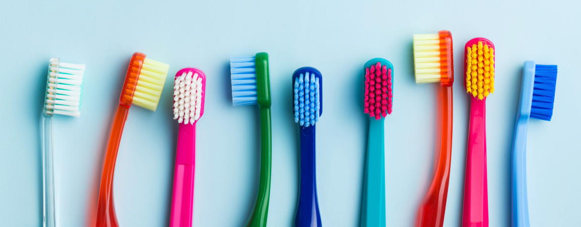 row of toothbrushes on blue background